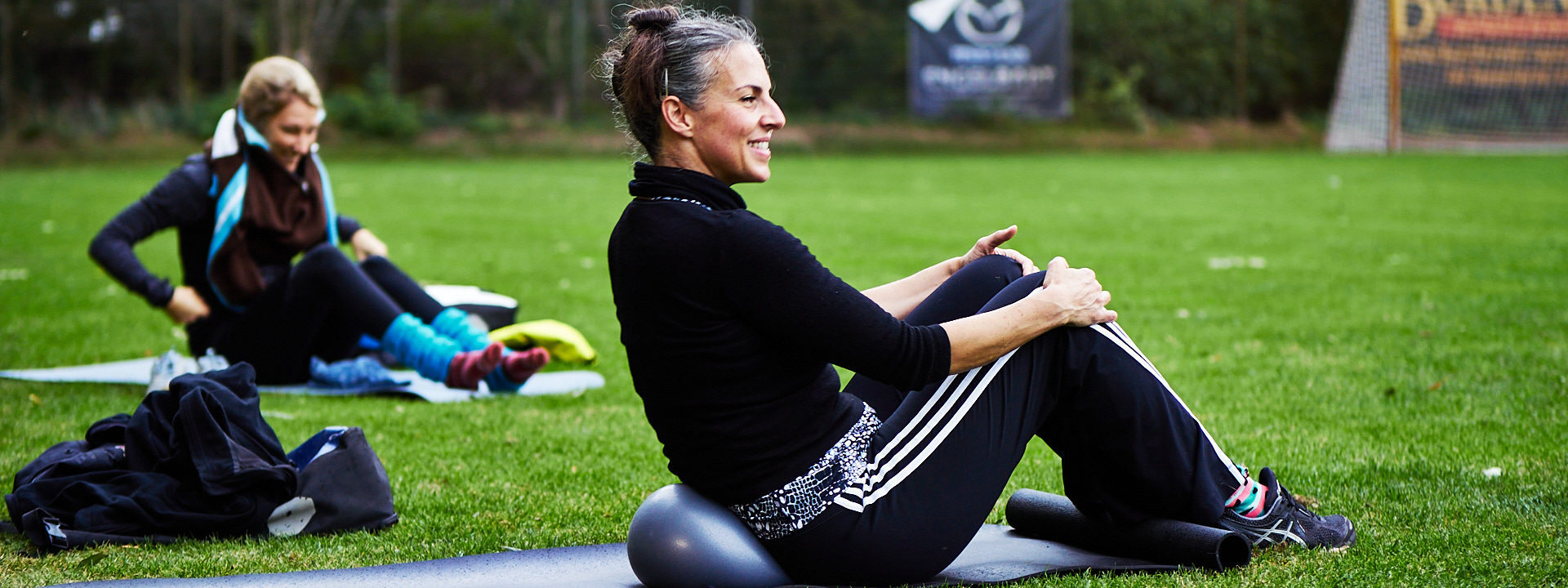 Susanne Meyer, Outdoorkurs leitend; sitzend auf Yogamatte