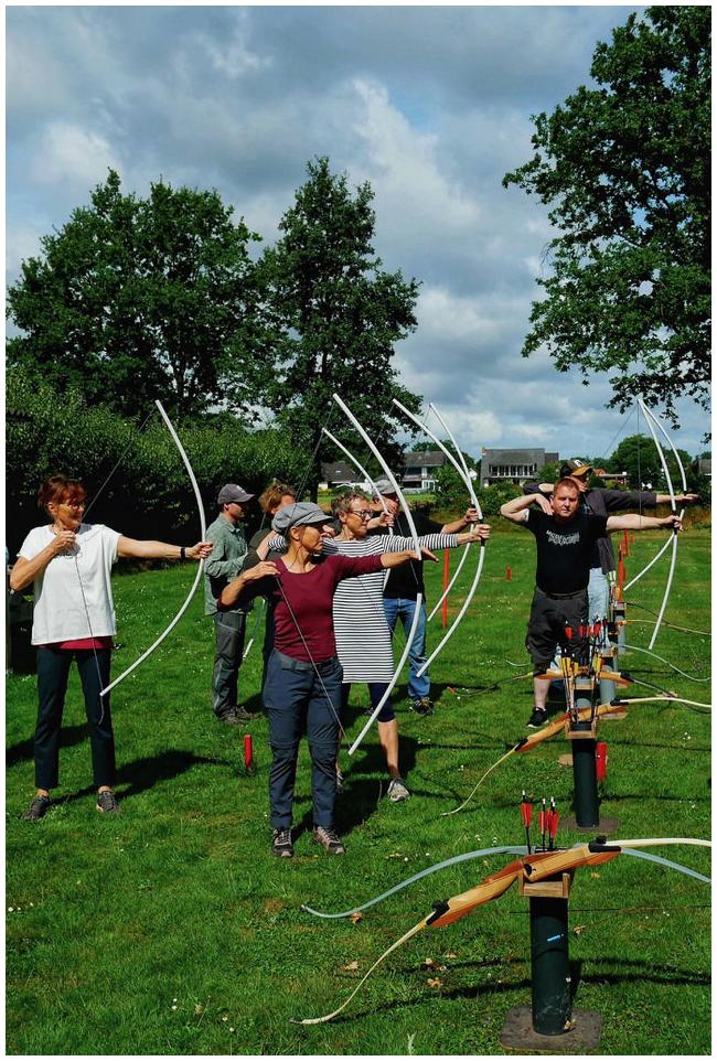 Gruppe Bogenschützinnen mit Übungsbögen