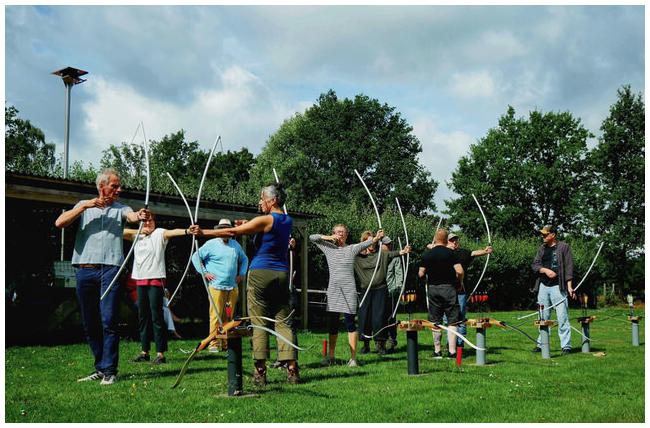 Gruppe Bogenschützinnen mit Übungsbögen