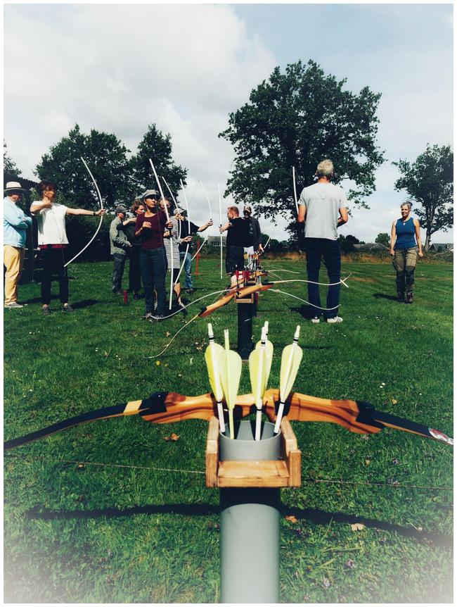 Gruppe Bogenschützinnen, im Vordergrund ein Bogen und ein Pfeilköcher