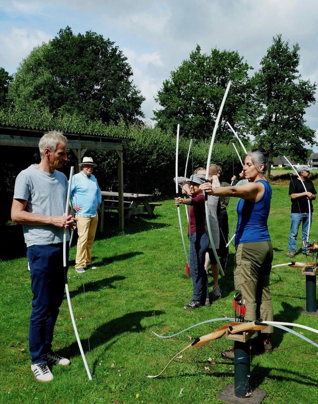 Gruppe Bogenschützinnen mit Übungsbögen