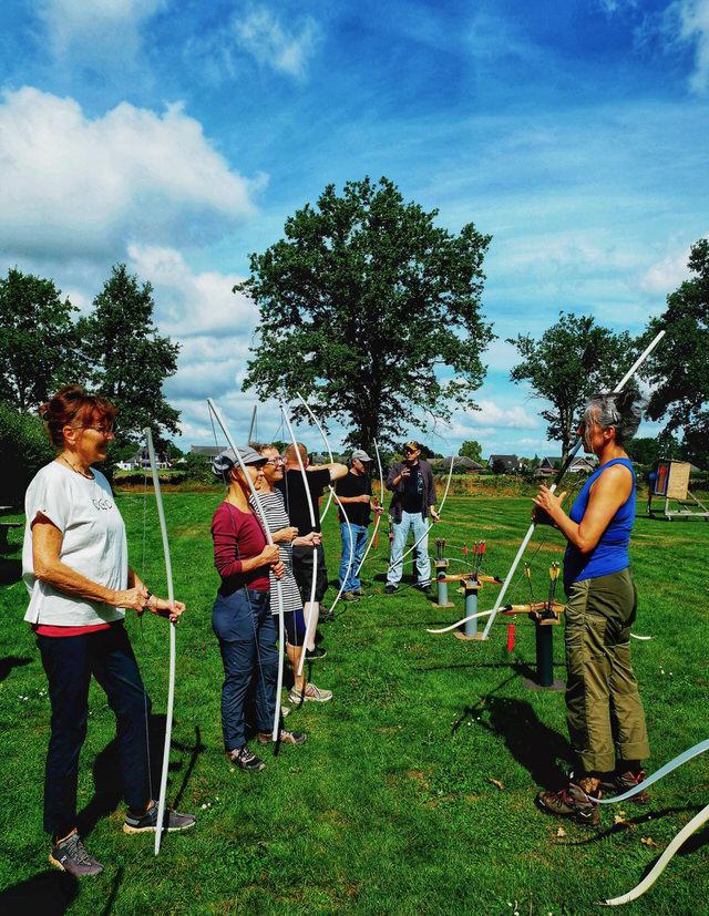 Gruppe Bogenschützinnen mit Übungsbögen